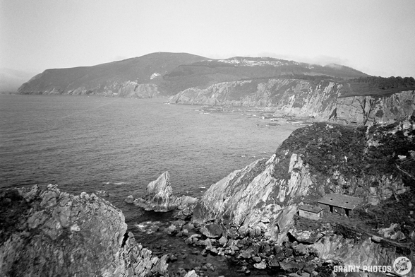 A black-and-white film photo of the rocky and rugged Loiba coastline