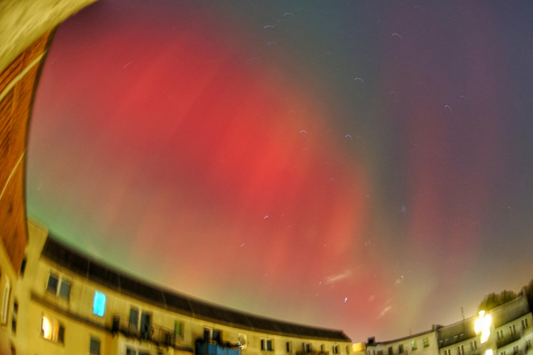 Rote und grüne Nordlichter über Plattenbauten