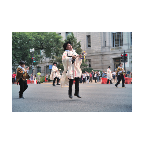Picture of a Peruvian dancer playing a traditional Peruvian guitar