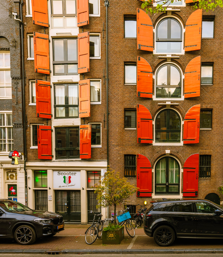 A quintessential Amsterdam street with iconic Dutch brown brick crooked architecture canal houses with vibrant orange shutters. The staple bicycles of Amsterdam streets parked at the doorsteps.
Captured by Komeil Karimi