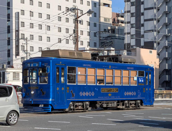 Ein historisch anmutende Straßenbahn in dunklem metallic blau.