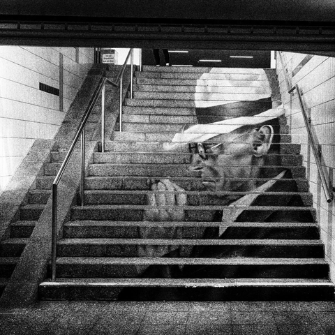 Seitliches Poträt von Hermann Hesse auf den Stirnseiten der Treppenstufen einer Unterführung. 
Zu sehen mit Hut und einer Zigarre in der sichtbaren linken Hand 