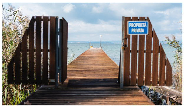 Blick auf einen Steg. An einem Schild steht "Privatbesitz". 