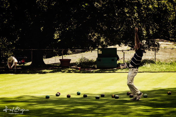 Man playing lawn bowling celebrates with hands raised in air in New York's Central Park