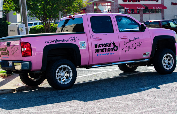 A very pink pick-up truck belonging to a non-profit organization called Victory Junction.  The photo was taken at a street festival and I knew nothing about the organization until today.