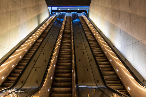 Set of three escalators rising up to ground level coming out of a Metro station exit in Washington D.C.