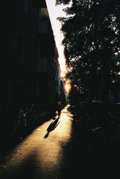 A person walking into a golden sunset, casting a long shadow