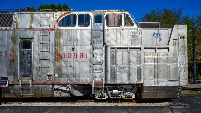 A front, right-side view of Union Pacific #900081.  This snowplow features a 12-foot diameter cutting wheel that would turn as fast as 150 revolutions per minute and could throw snow up to 300 feet away from the tracks.  The cutting wheel was driven by a 16-cylinder 3,000-horsepower turbocharged diesel engine.  It was not self-propelled and had to be pushed by at least three locomotives.  This snowplow was last used in 1994 in Wyoming.