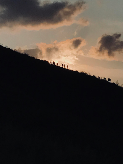 Quelques petites silhouettes sur les pentes du Stromboli; le ciel rougeoie au couchant du soleil