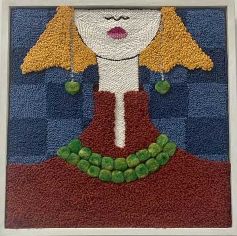 A textile artwork of the partial face and shoulders of a young woman. She has full yellow hair that falls several inches below her ears, and is wearing a high-necked, dark red dress. She's displaying a double strand necklace of emeralds or emerald-colored large beads, and matching hanging earrings. Made using hand-tufting and needling-felting techniques.