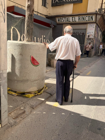 a small watermelon painted on a wall by escif