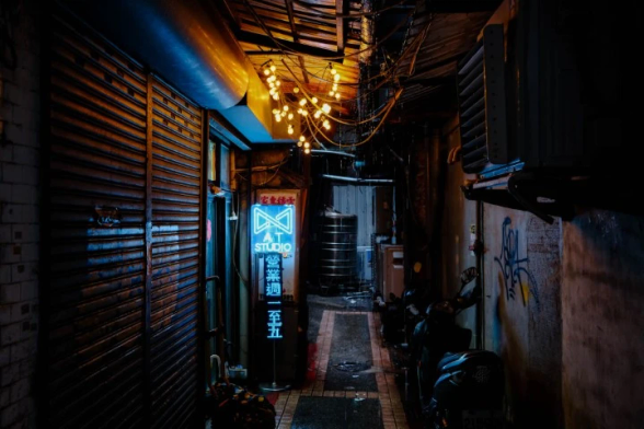 A dark alley whith some lights and rain.