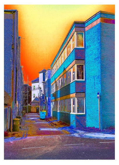 Colour modified portrait photograph of an alley between buildings.  Toward the end of the alley to the left can be seen scaffolding.  To the right many windows and blue bricks.