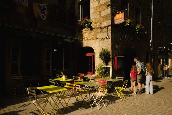 Street partially in the dark because of a low sun and tall buidlings