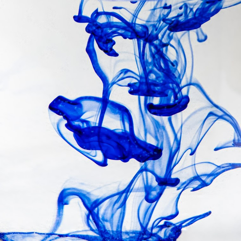 Swirls of blue ink over a white background. The ink patterns looks a bit like jellyfish.