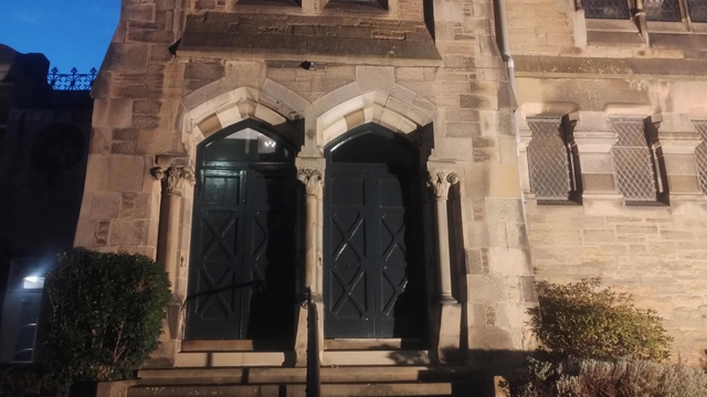 Twin doors with Gothic arches above, on the corner of King's Church at night