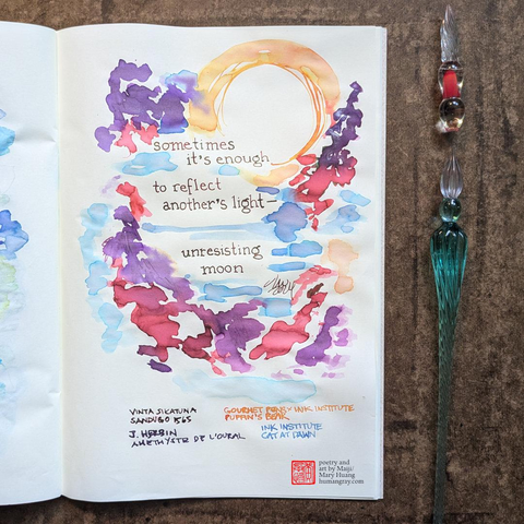 Photo of notebook next to two glass dip pens, one of which is just a tip. The page shows a handwritten haiku surrounded by ink lines and splotches suggesting a scene with a warm orange moon over a blue-purple lake with branches of red and glittering purple peeking in at the edges and being reflected in the water. 
"sometimes it’s enough
to reflect another’s light—
unresisting moon"
- Poetry and art by Maiji/Mary Huang, humangray.com