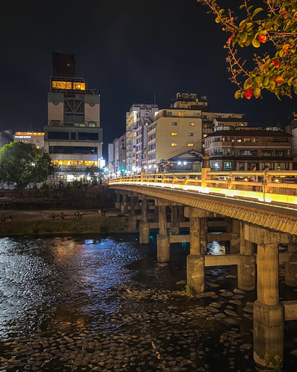 Vista de uno de los puentes que cruzan el río Kamo con la barandilla iluminada.