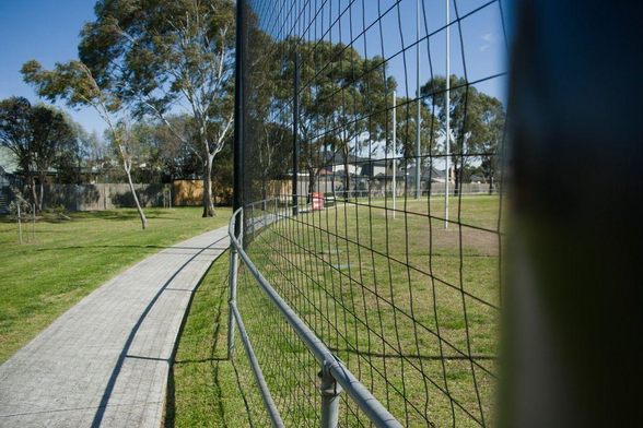 Photo of one end of an Australian Rules Football field in which tall nets have been installed behind the goal posts.
