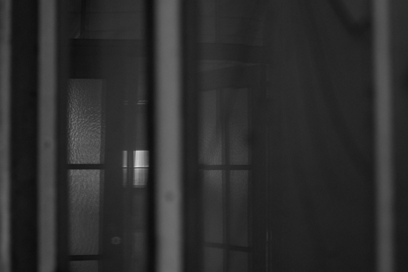 Fensterspiegelung mit mehreren vertikalen und horizontalen Rahmenstrukturen in dunkler, reduzierter Transparenz.