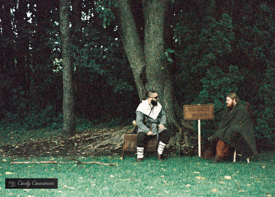 Deux personnes habillées en médiéval qui parlent ensembles dans la forêt. Photographie par Cindy Cinnamon 