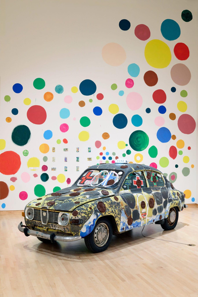 an installation of a painted car by Tyree Guyton against polka dotted walls