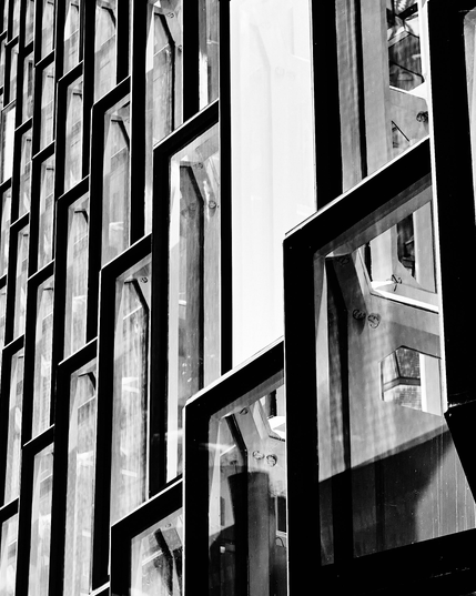 This black and white photograph captures the intricate geometric design of Harpa's facade in Reykjavik. The play of light and shadow across the glass panels creates a dynamic and bold visual effect, showcasing architectural elegance in monochrome.