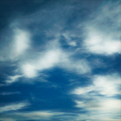 Wispy clouds drift through a bright blue sky.