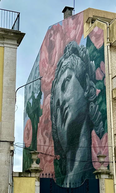 Mural of face resembling Statue of Liberty. 