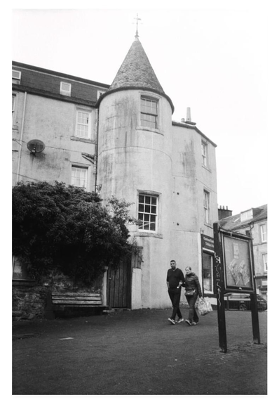 Black and white portrait film photograph of a pedestrianised backstreet in Oban, Scotland.