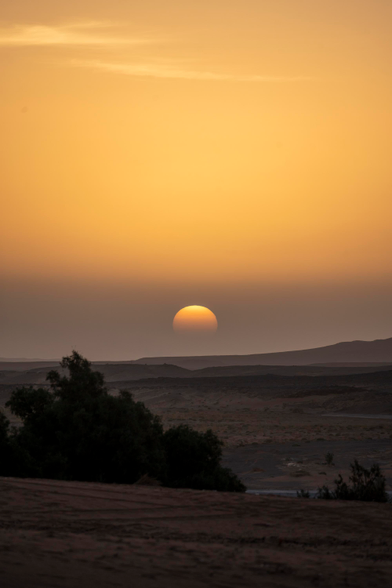 Th golden light of sun fading behind the dunes, painting the horizon in warm orange tones.