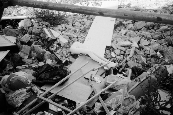 공터에 철거된 건물 파편과 각종 쓰레기가 널부러져있고 그 가운데 마네킹 하반신이 덩그러니 놓여있다.