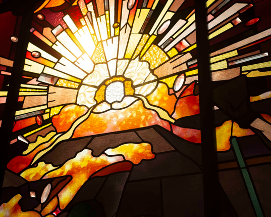 Vitrail abstrait représentant une explosion de lumière,  dans des tons jaunes, orangés et rouges