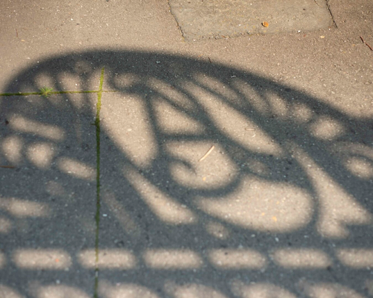 Ombre du portail de l'usine portée sur le sol en béton.