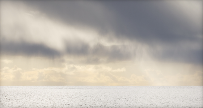 Colour photograph of a seascape, taken against the light at midday. The horizon lies roughly midway down the lower half of the image. Below it stretches a bright, empty sea, while above, showery clouds are partly lit by the sun. © Nika Potinkara