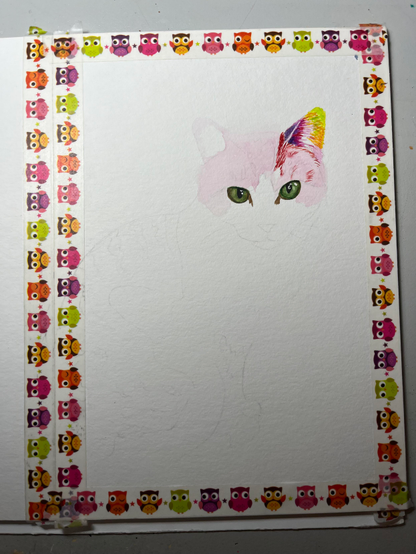 weißes Blatt Papier umrandet mit buntem Eulen-Washitape. Ein kolorierter Katzenkopf: die grünen Augen stechen hervor, das rechte Ohr ist bunt gehalten in grün, orange, rot und lila. Der restliche Katzenkopf ist hell rosa schattiert. Der restliche Katzenkörper ist mit Bleistift hauchzart vorgezeichnet. 