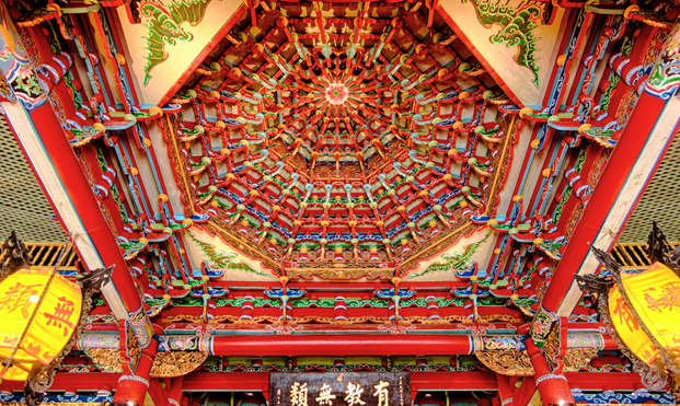 Richly decorated ceiling inside a temple hall.