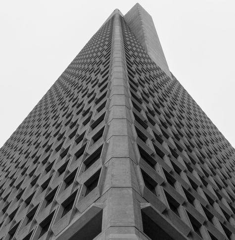 A black and white image of the Transamerica Pyramid, symmetrical about one of the corners - except for one of the "fins" near the top is visible, breaking the symmetry just slightly