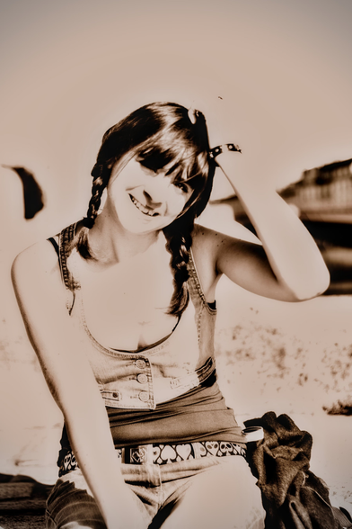 Sepia portrait format photo of a young woman with dark hair tied in 2 braids, scratching her head and smiling