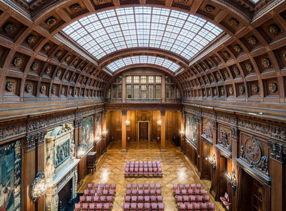 an image of an assembly hall in the palace, paintings on the walls, it is dark brown, a half - oval roof over the room 