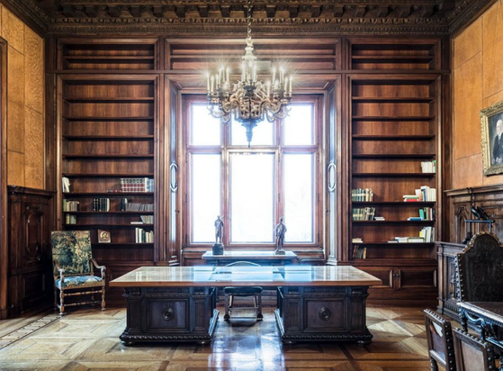 an office in the palace, a chandelier hanging from the ceiling, it is really pretty but not overdecorated 