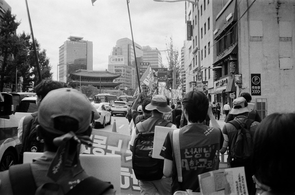 회계공시·타임오프 폐기 촉구 금속노조·민주일반노조 공동투쟁대회를 마친 민주일반노조 조합원들이 9·13 민주노총 결의대회에 참여하기 위해 현수막과 깃발을 들고 서울 시내를 행진하고 있다. 저 멀리 숭례문이 보인다.