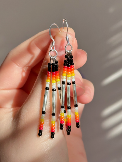 The finished pair of drop earrings held up in the light