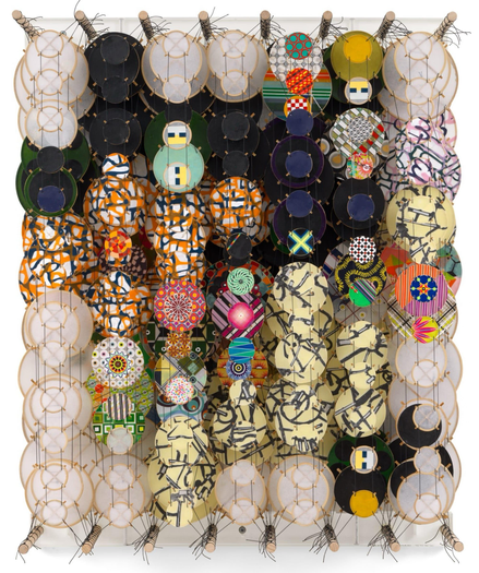 an abstract artwork by Jacob Hashimoto made from twine and numerous colorful, patterned paper discs installed in rows for a layered effect