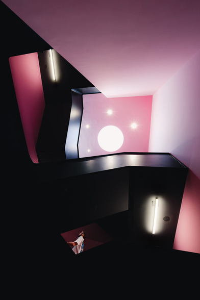 A wide staircase view from below. A person is framed by the stairs.