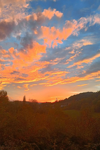 sunset. cloud are orange mainly on the left side. sky is blue.
note: the sun disappeared 1 min before the photo was taken.