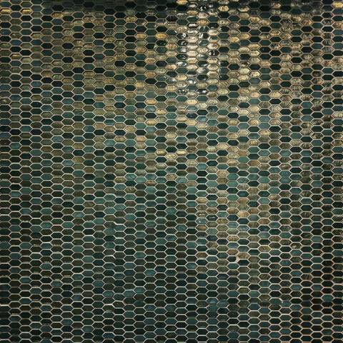 A wall fills with small emerald and gold hexagonal tiles.