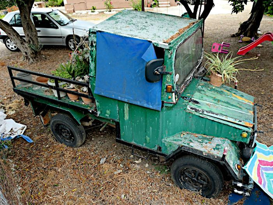 Foto van oud, groen vrachtautootje, nu in gebruik om planten op te zetten