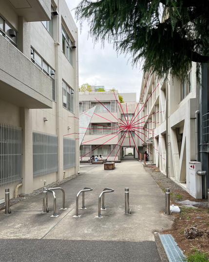 Una zona del campus con un edificio decorado con una especie de telaraña de líneas rojas que cruzan paredes, ventanas, ..., e incluso cubren varios edificios. No hice la foto desde el punto más adecuado, pero creaba un efecto visual, como si alguien hubiera hecho una foto de los edificios y, luego, hubiera pintado las líneas rojas encima.