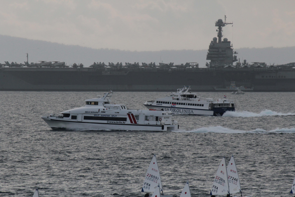 Two smaller liners agains the backdrop of the large American carrier.
